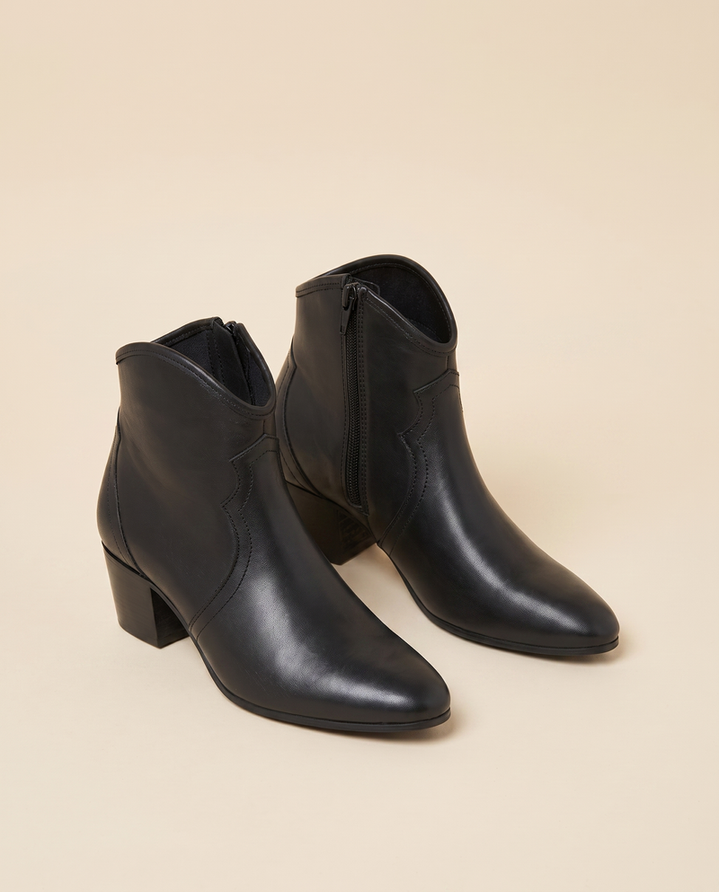Boots ALIENA noires debout sur fond beige