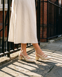 Slingback DEOTILLE écrue portée, gros plan, sur les pavés d'une rue londonienne