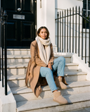 Boots fourrées ICECREAM beige portées, femme assise sur le perron d'une maison londonienne