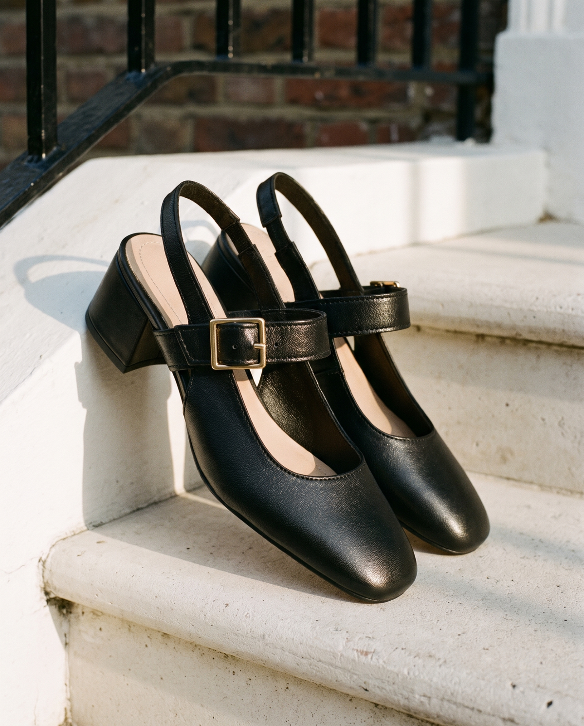Slingback MONA noire posée sur le perron d'une maison londonienne