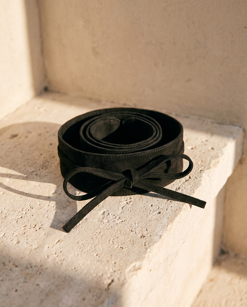 Ceinture SARAH noire à nœud enroulée sur une marche en pierre — A by André