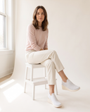 Basket SHAKI blanche portée, femme assise sur un tabouret blanc en studio